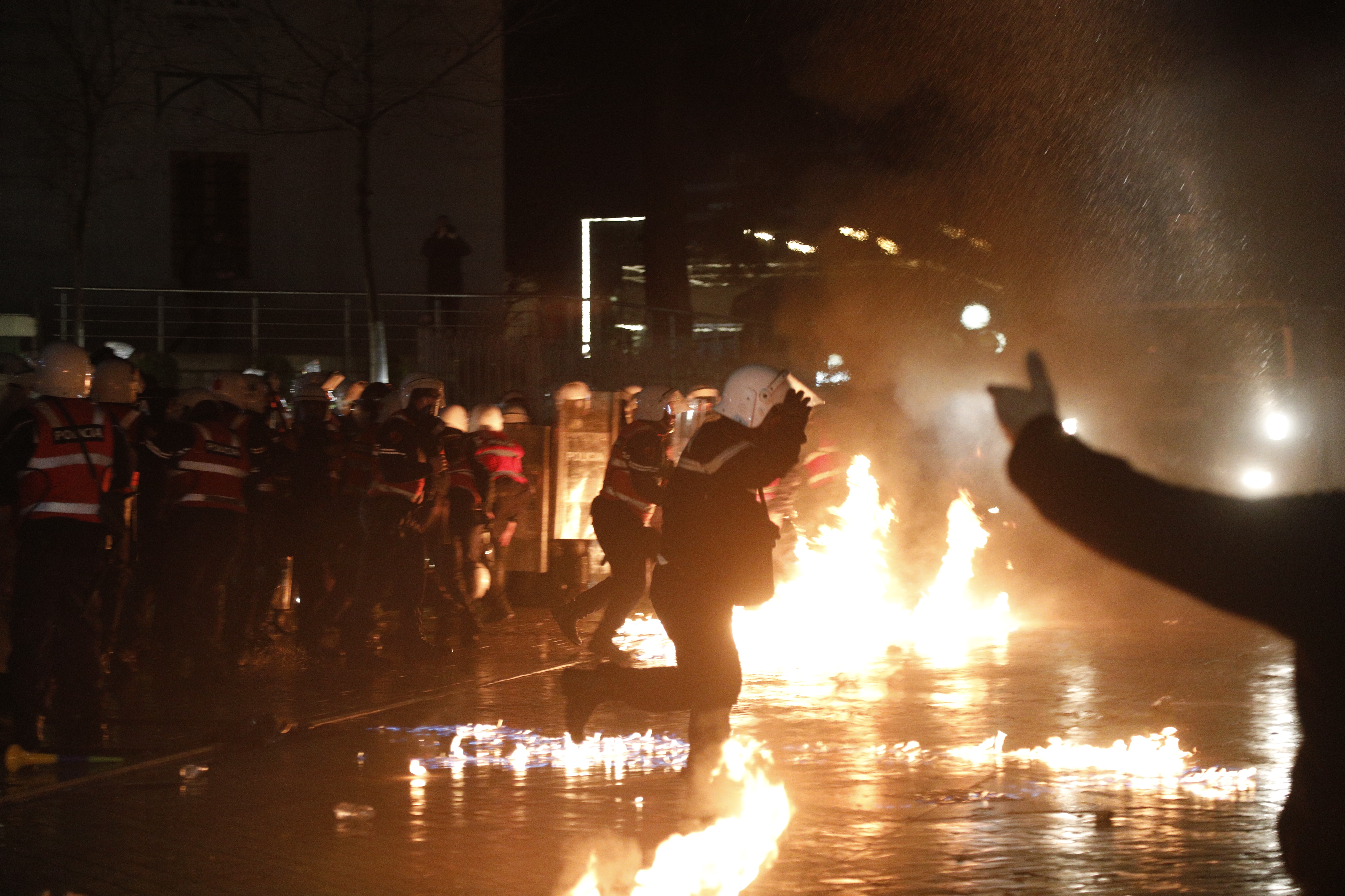 epa12725109 Police officers move away from a fire during an anti-gove