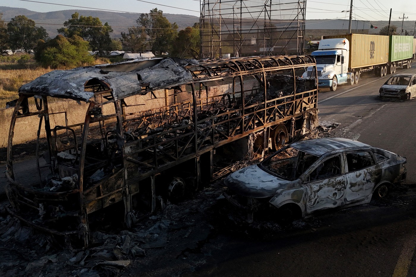 A view of a burned bus and car, allegedly set on fire by organised crime groups in response to an operation to arrest a high-priority security target, on a highway near Acatlan de Juarez, Jalisco state, Mexico taken on February 22, 2026