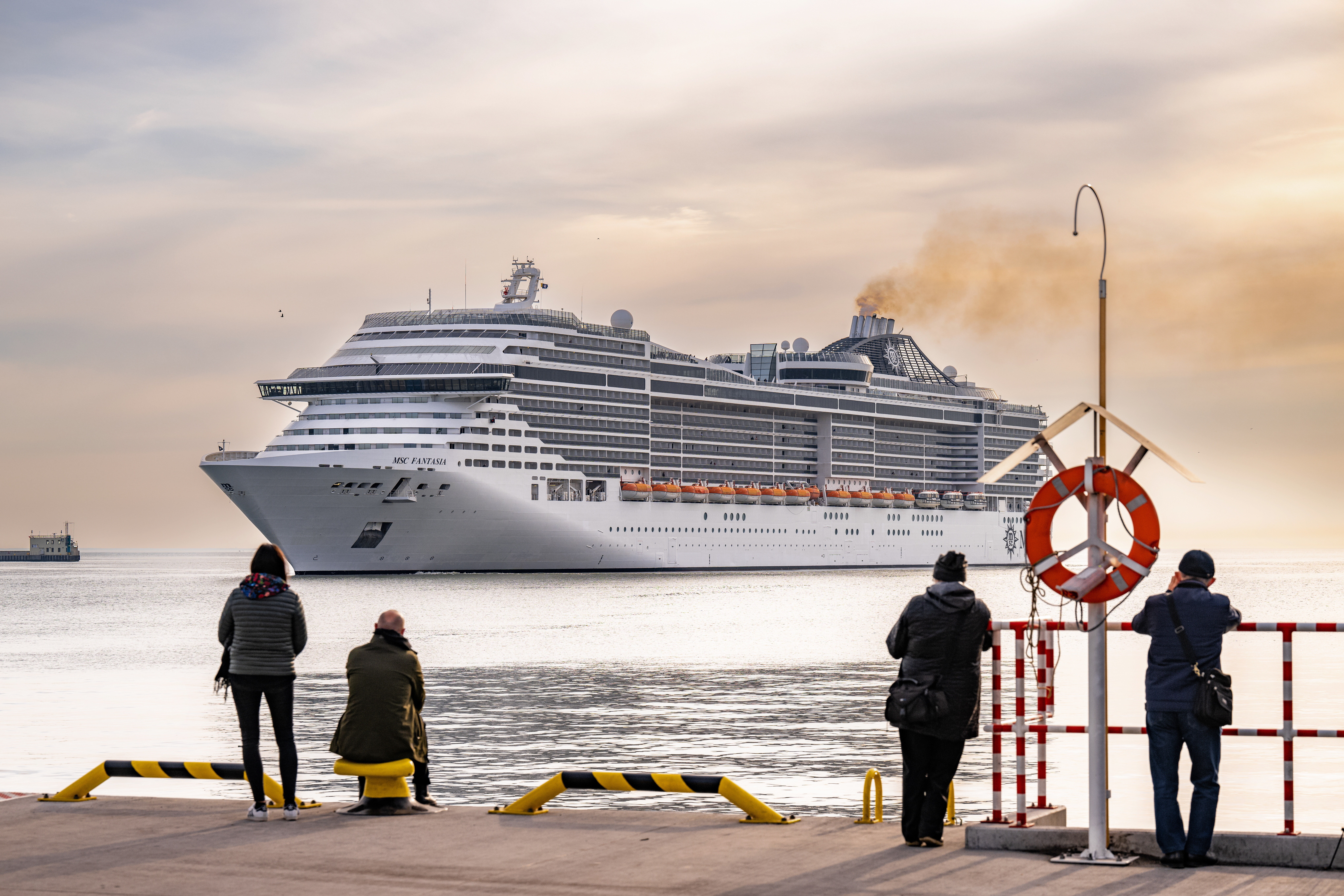 epaselect epa10604034 People look as the first cruise ship of the season - MSC Fantasia - enters the port of Gdynia, Poland, 02 May 2023. MSC Fantasia is the longest vessel that the port of Gdynia will host this year.  EPA/MARCIN GADOMSKI POLAND OUT