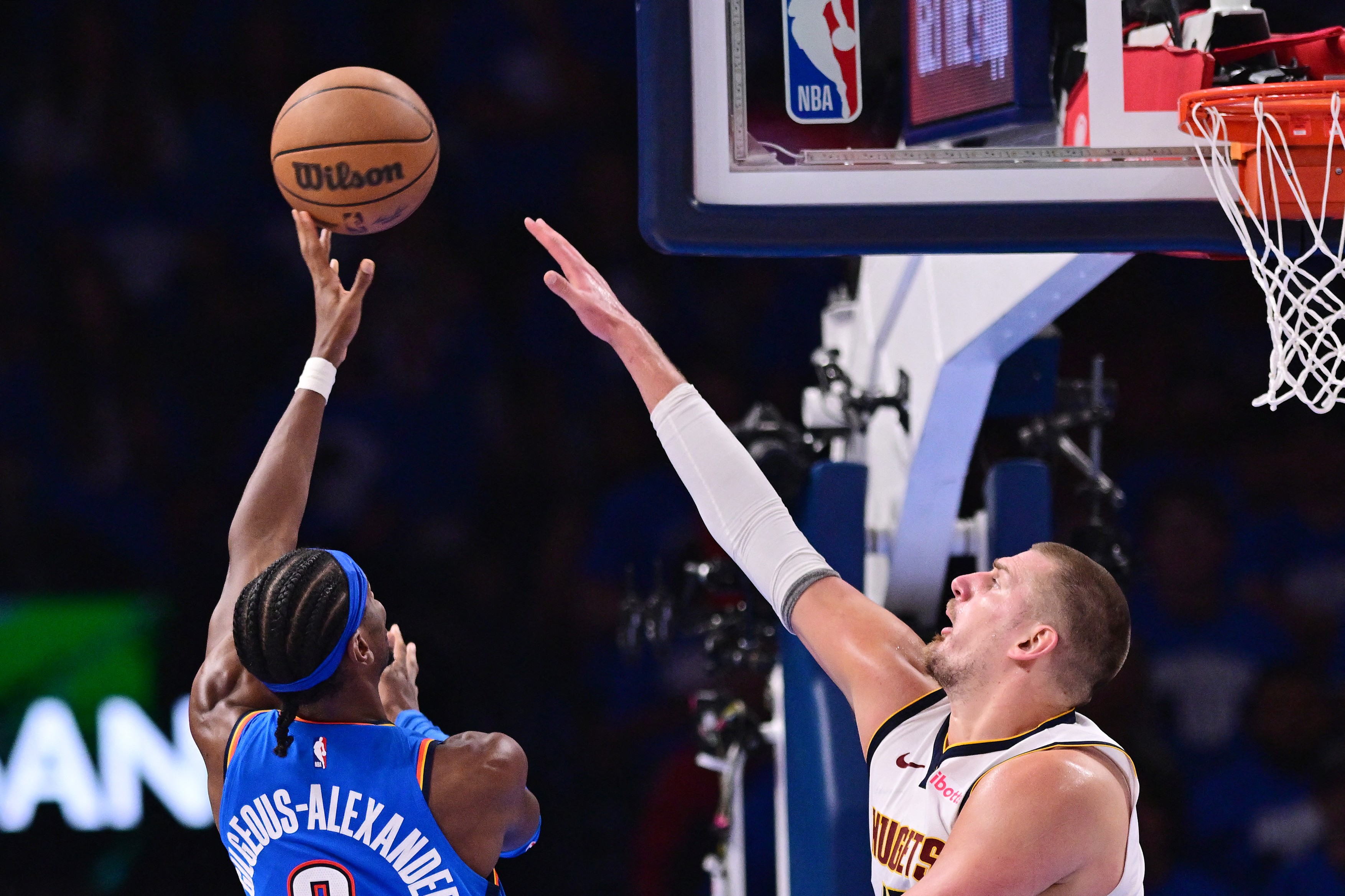 Shai Gilgeous-Alexander #2 of the Oklahoma City Thunder shoots the ball over Nikola Jokic #15 of the Denver Nuggets