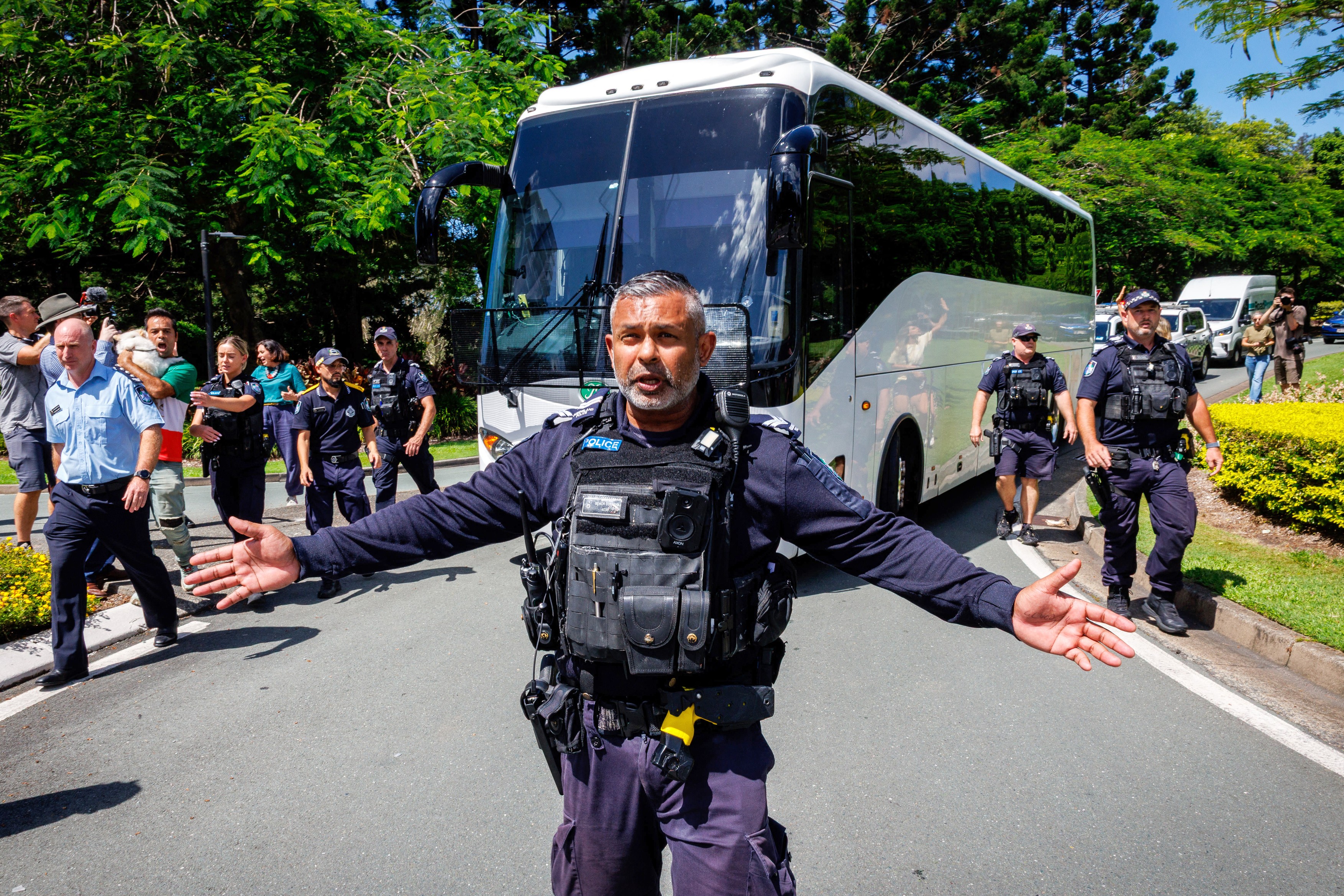Police officers clear the road for a departing bus transporting members of the Iranian Women’s Asia Cup football team