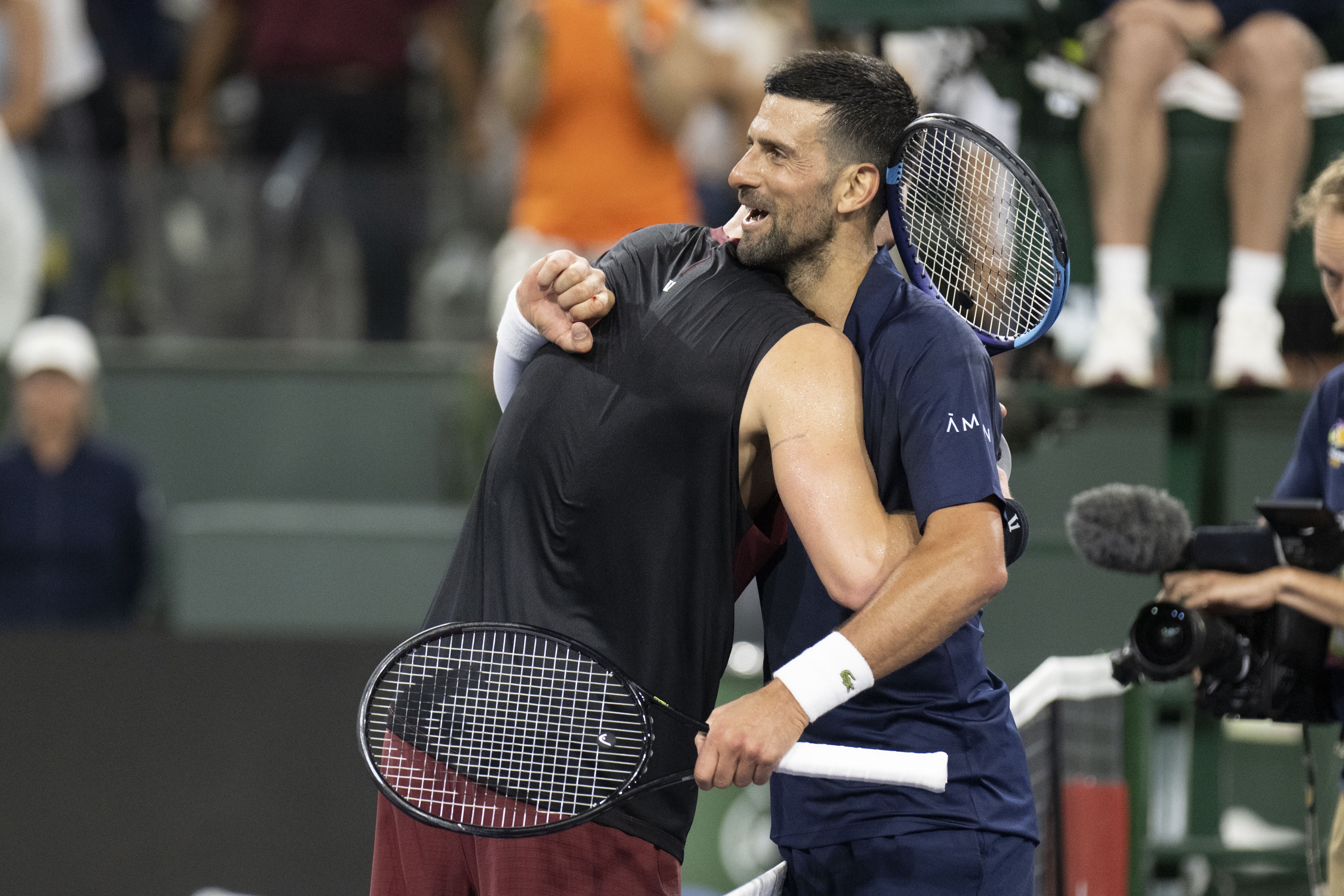 JACK DRAPER of Great Britain gives NOVAK DJOKOVIC of Serbia an emotional hug after winning their round of 16 match at the BNP Paribas Open at Indian Wells Tennis Garden