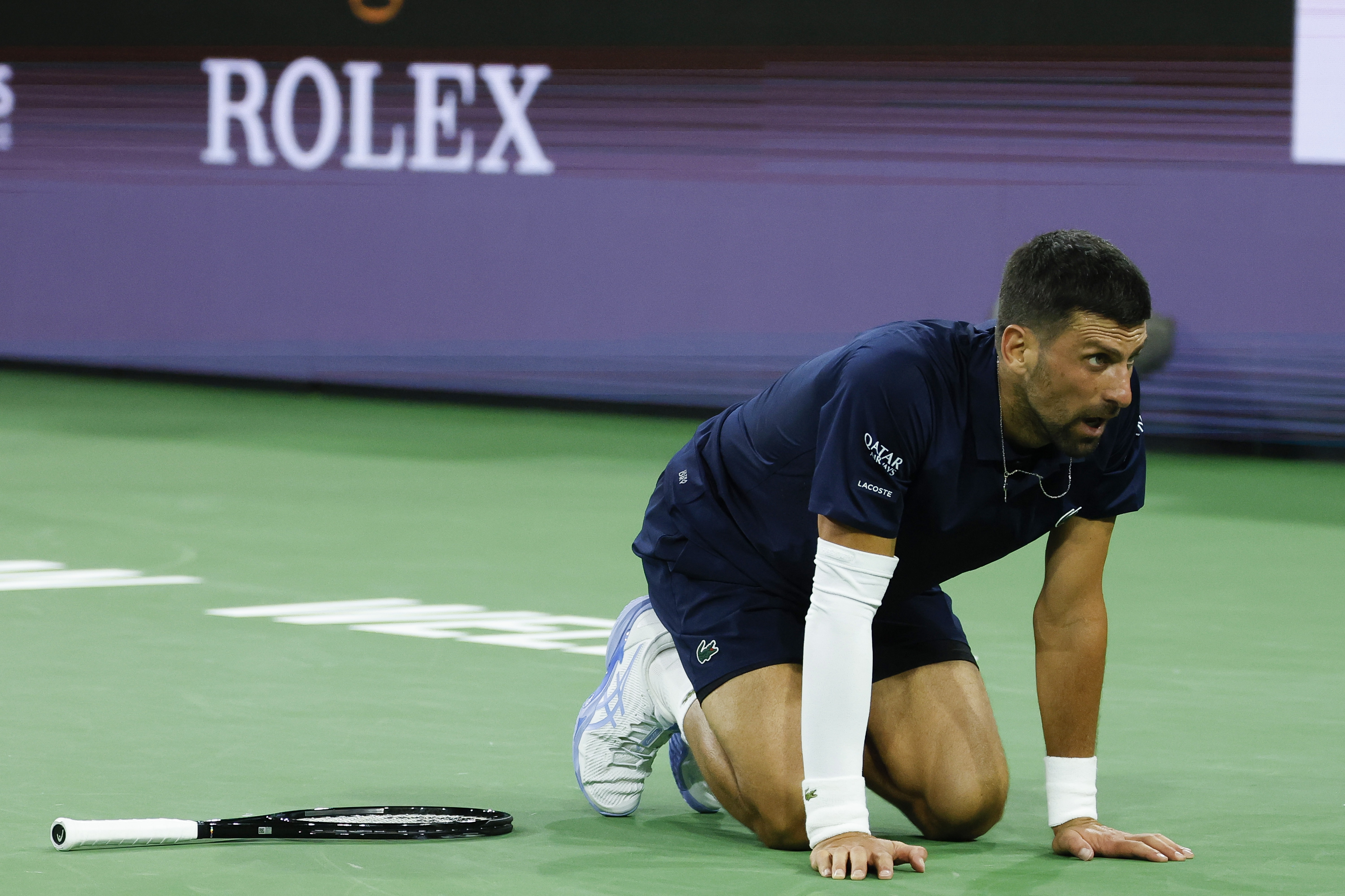 Novak Djokovic of Serbia falls to the ground
