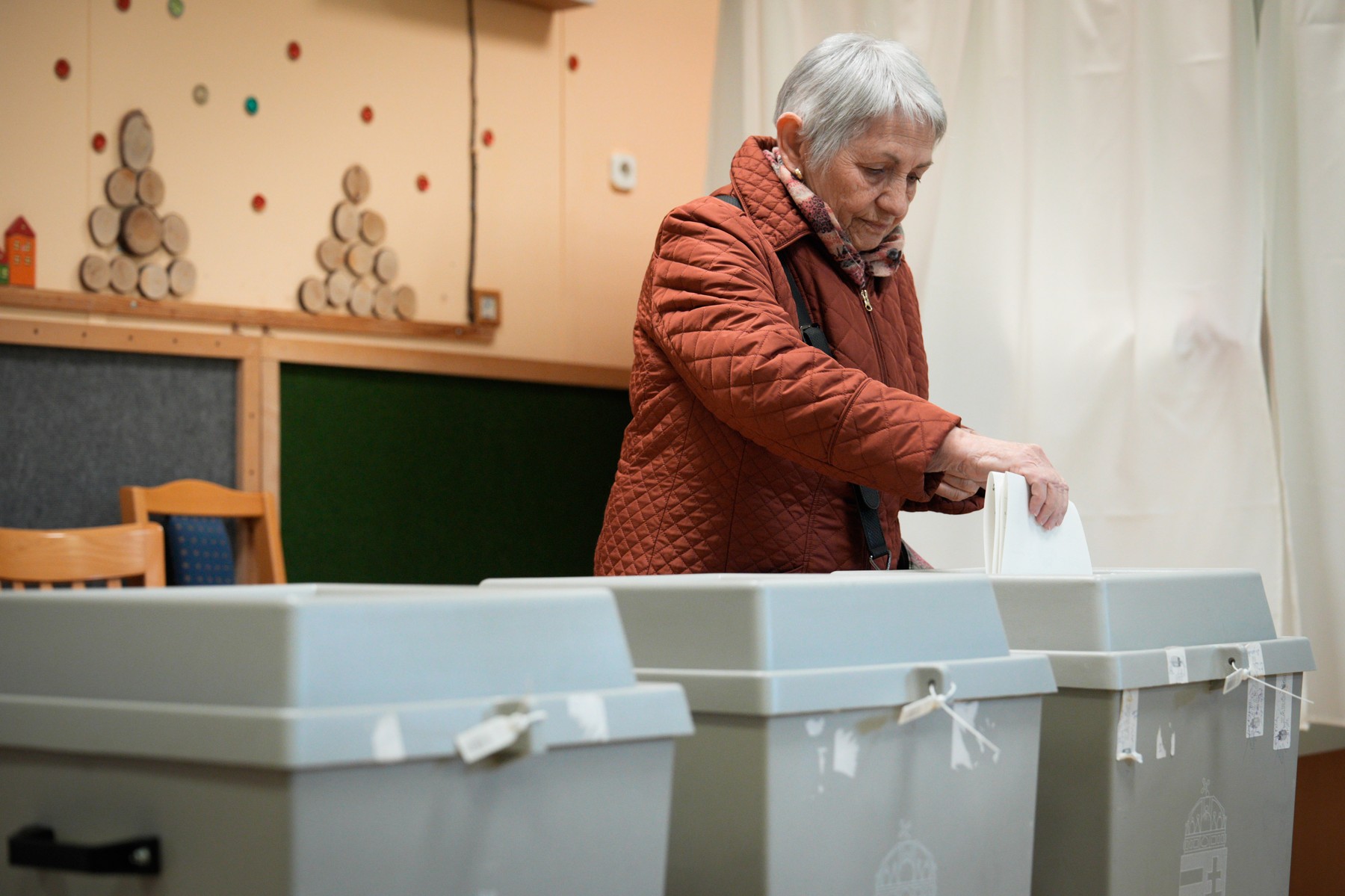 A woman places her ballot at a voting station i037640