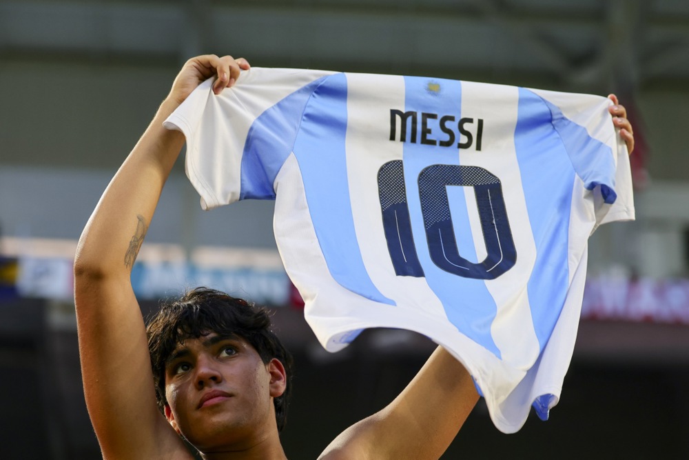 epa12188514 A fan holds up a Lionel Messi