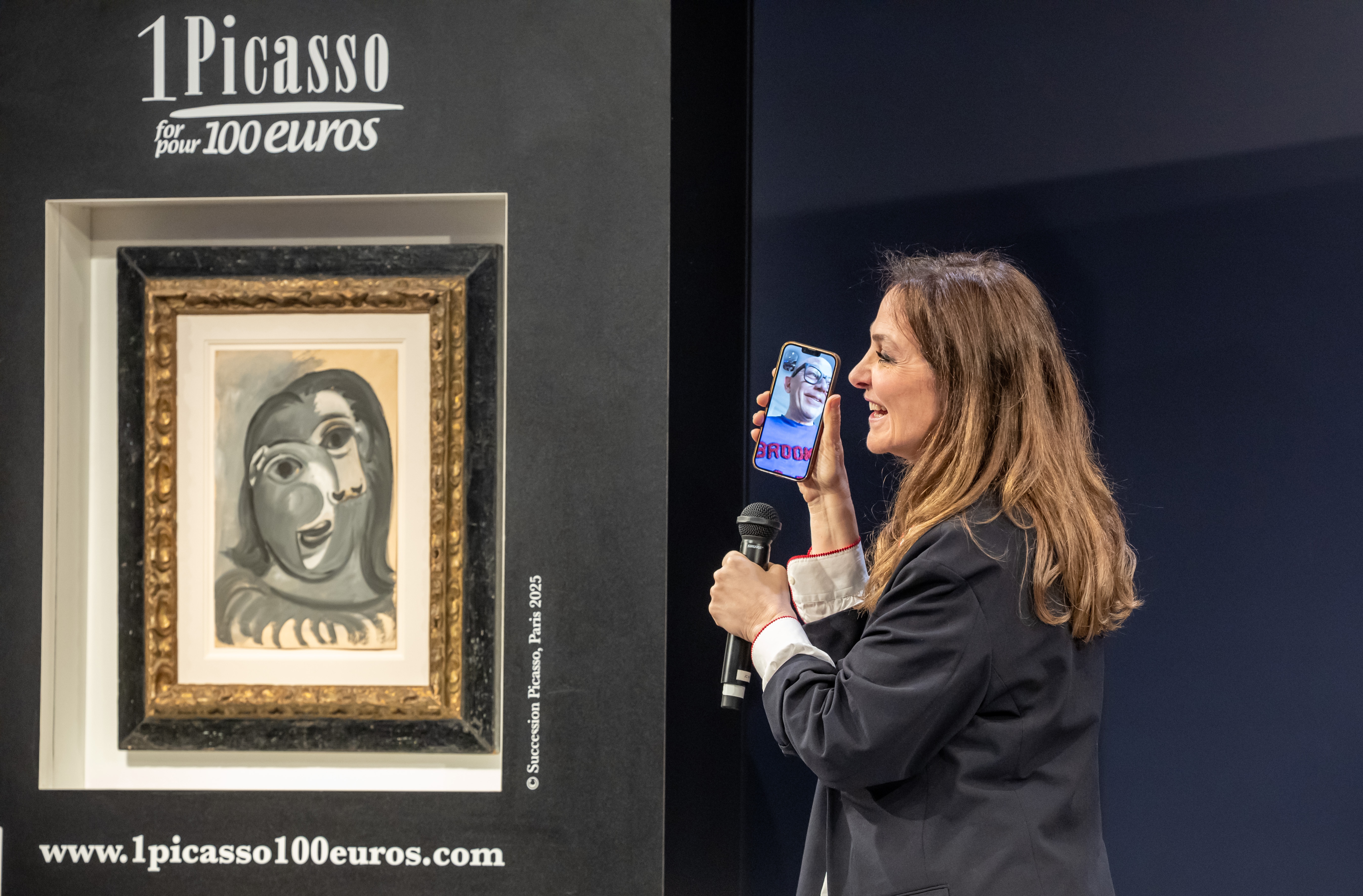 epa12889864 Peri Cochin, founder of the charity '1 Picasso for  100 euros' charity raffle at Christie's Paris’, speaks on the phone with the winner at the raffle draw to win Pablo Picasso’s work ‘Portrait of Dora Mar’ in Paris, France, 14 April 2026.