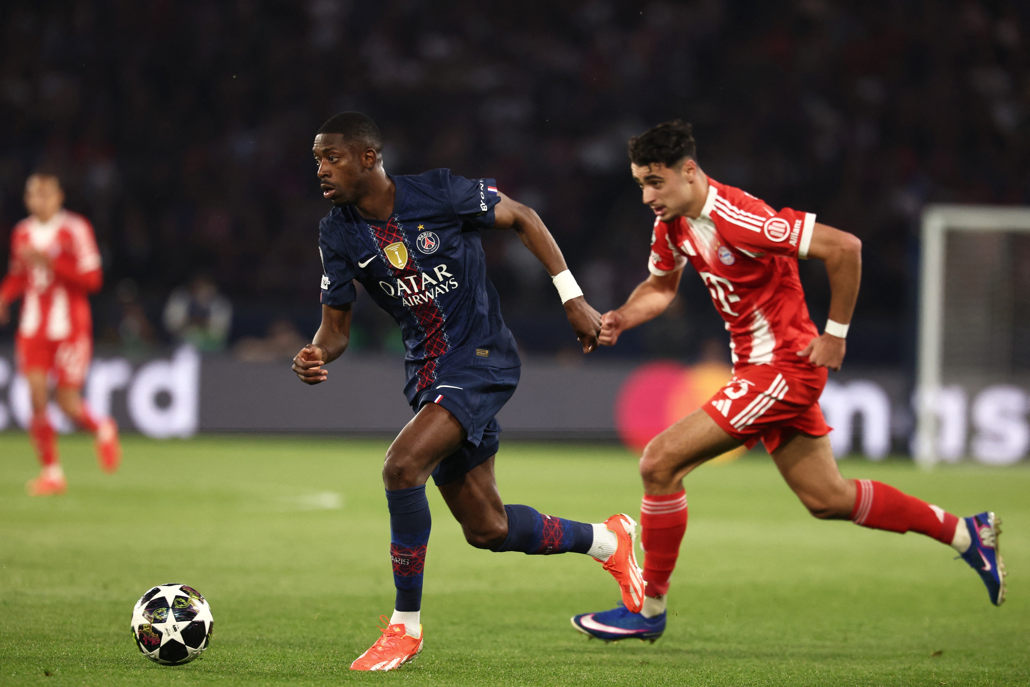 Paris Saint-Germain's French forward #10 Ousmane Dembele fights for the ball with Bayern Munich's German midfielder #45 Aleksandar Pavlovic during the UEFA Champions League semi-final first leg