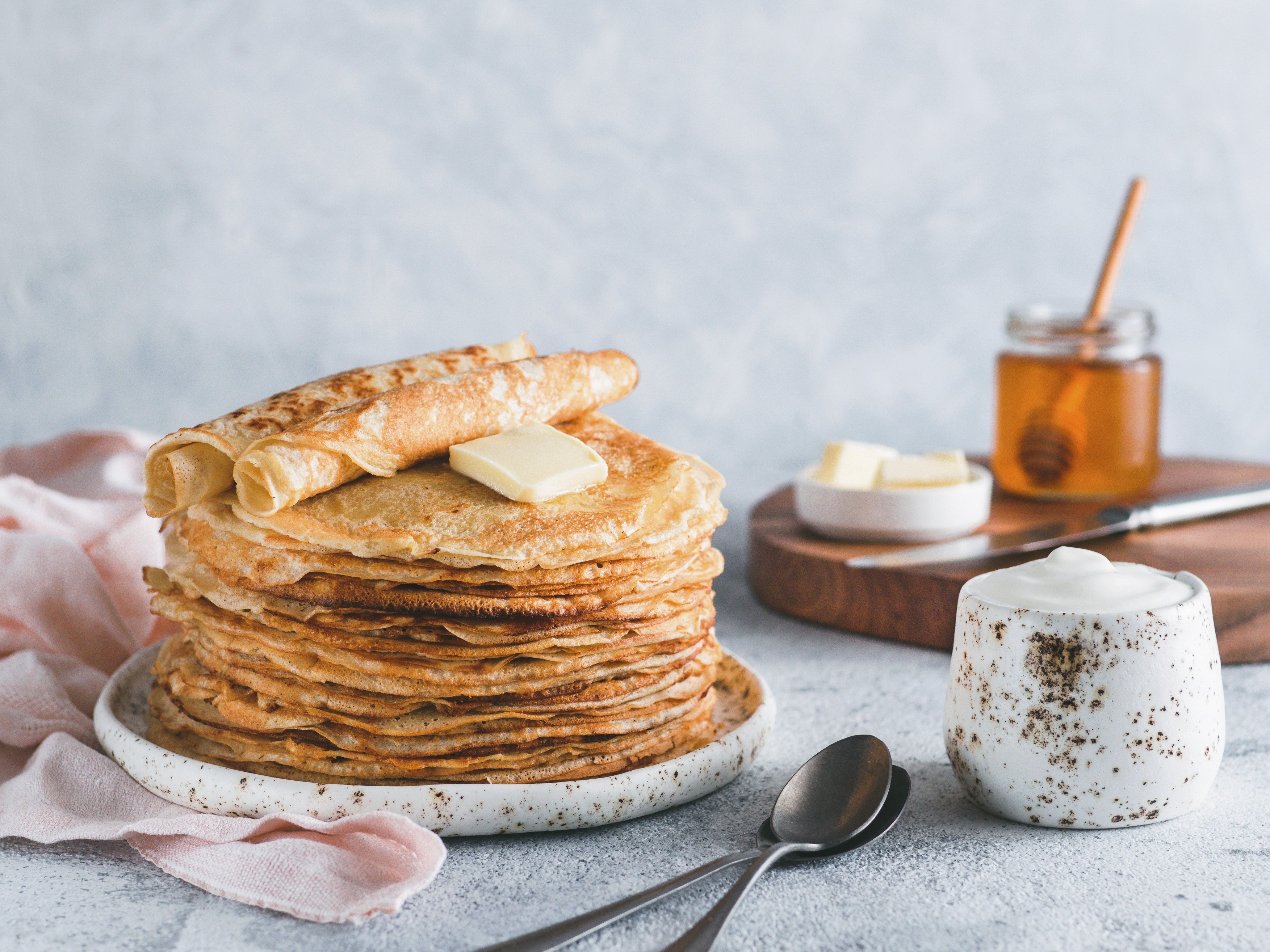 Stack of traditional russian pancakes blini on gray background with copy space.