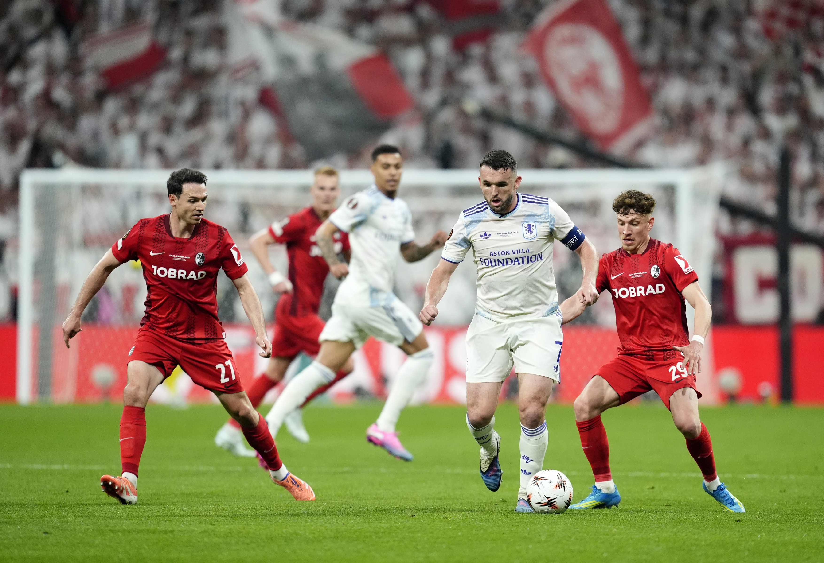 Aston Villa's John McGinn (second right) and Freiburg's Philipp Treu (right) battle for the ball