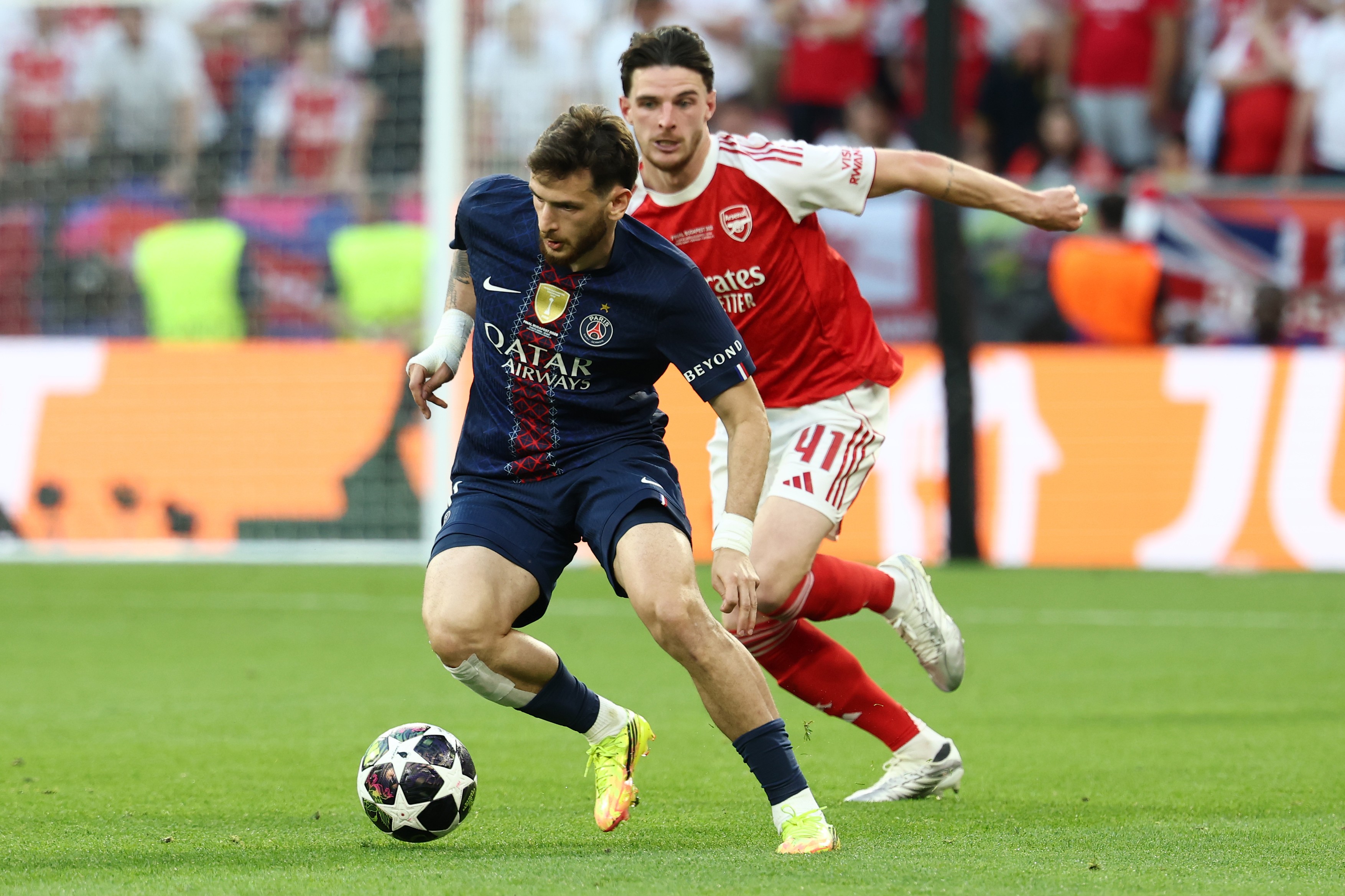 Khvicha Kvaratskhelia of PSG and Declan Rice of Arsenal compete for the ball