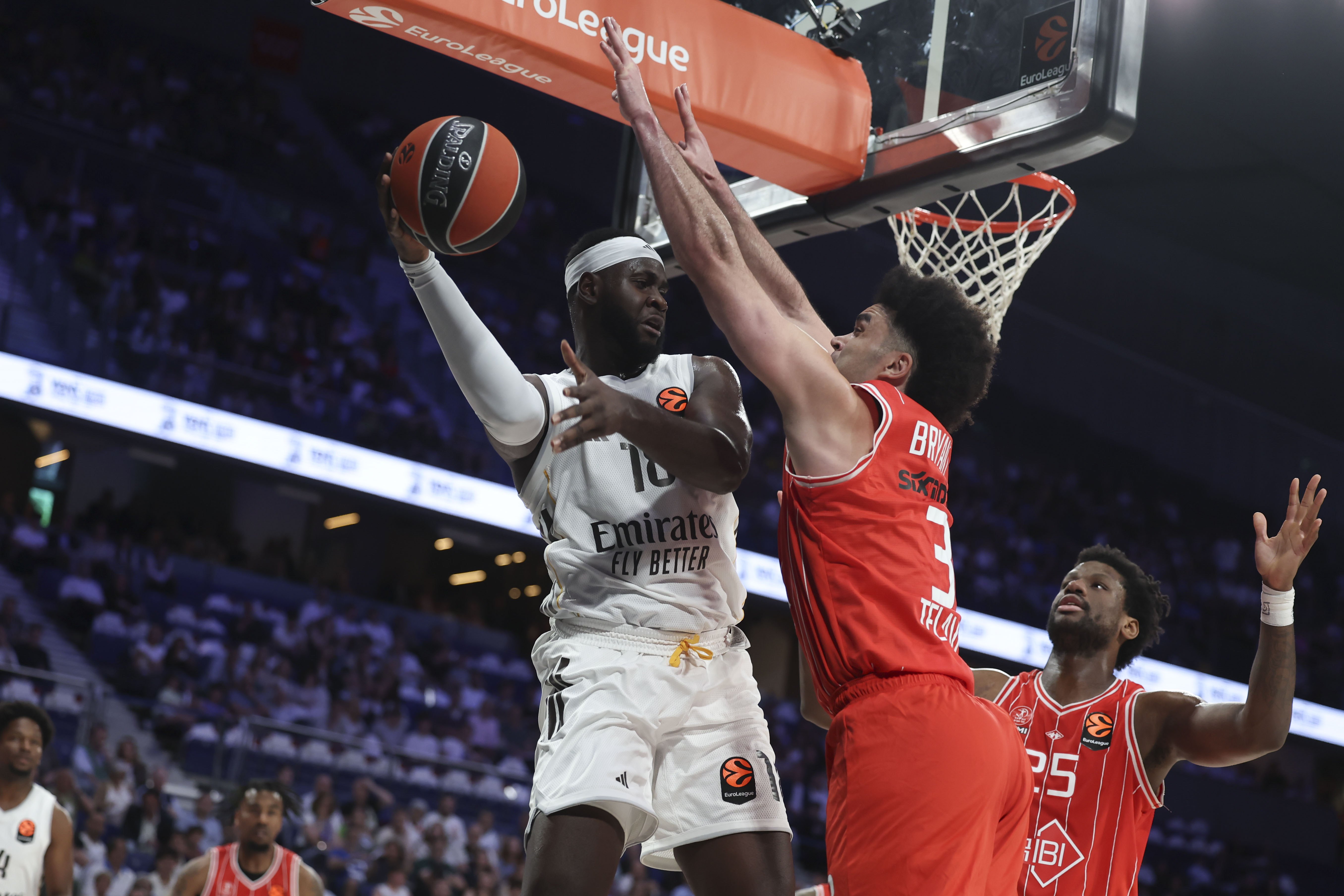 Real Madrid's Usman Garuba (L) in action against Hapoel's Elijah Brigham Bryant (C)