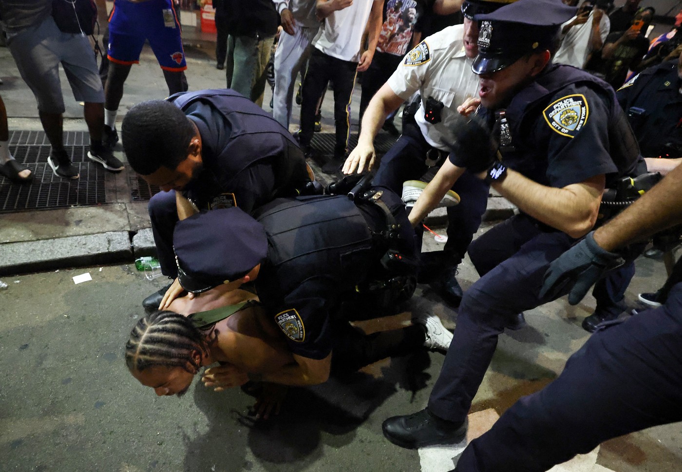NYPD officers detain a man after clashes outside Madison Square Garden,