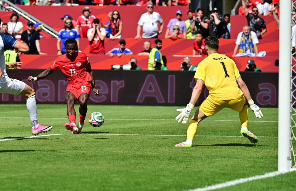 epa13033494 Richie Laryea of Canada (L) in action against goalkeeper Nikola Vasilj of Bosnia and Herzegovina during the FIFA World Cup 2026 group stage match Canada against Bosnia and Herzegovina, in Toronto, Canada, 12 June 2026.  EPA/EDUARDO LIMA