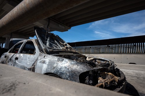 A burned car, allegedly set on fire by organized crime groups, is seen on Inte