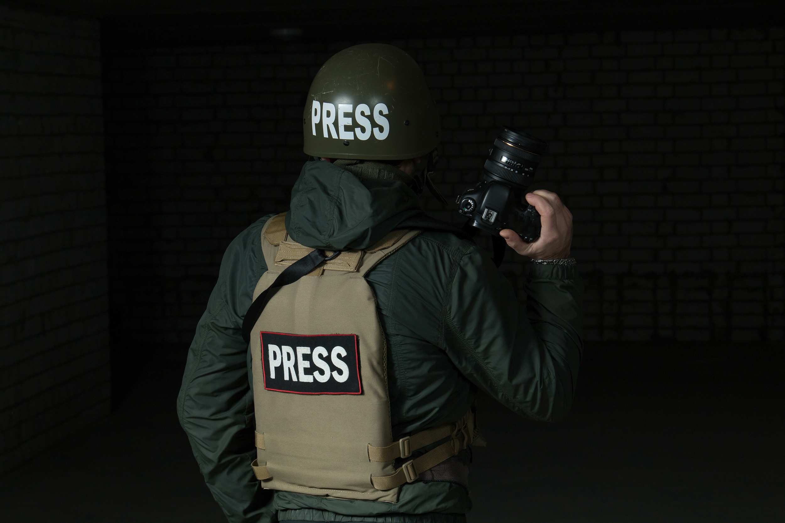 Photojournalist in a helmet and flak jacket wore protective equipment for shooting in the conflict zone