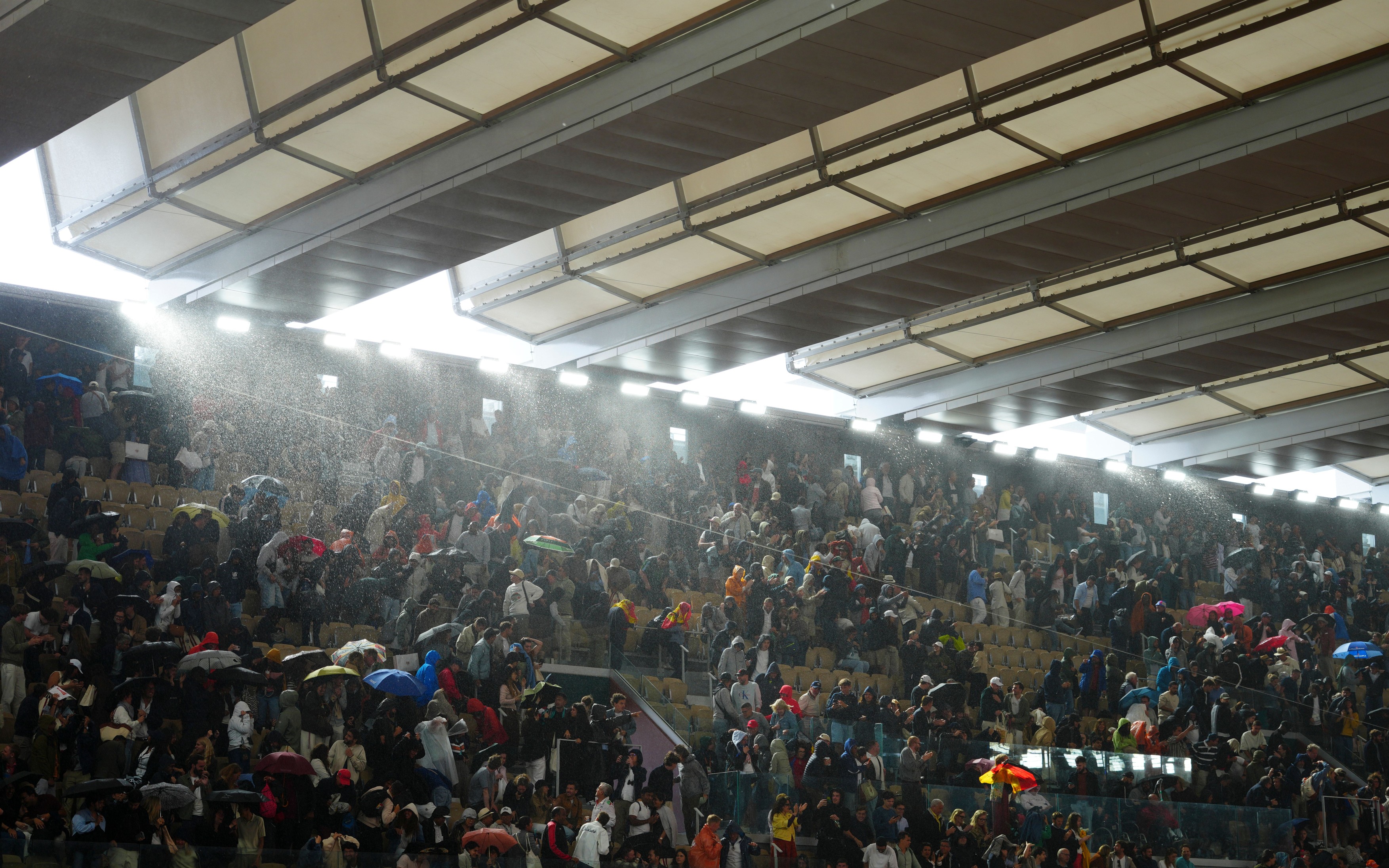 Spectators run for cover as rain