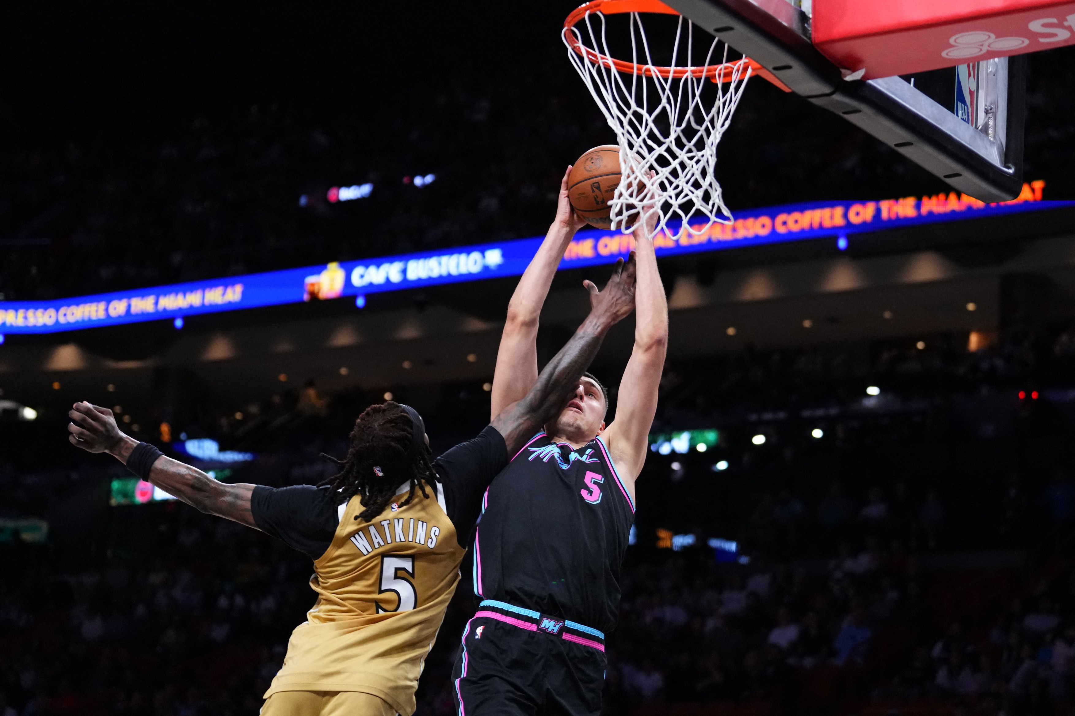 MIAMI, FLORIDA - APRIL 04: Jamir Watkins #5 of the Washington Wizards fouls Nikola Jović #5 of the Miami Heat