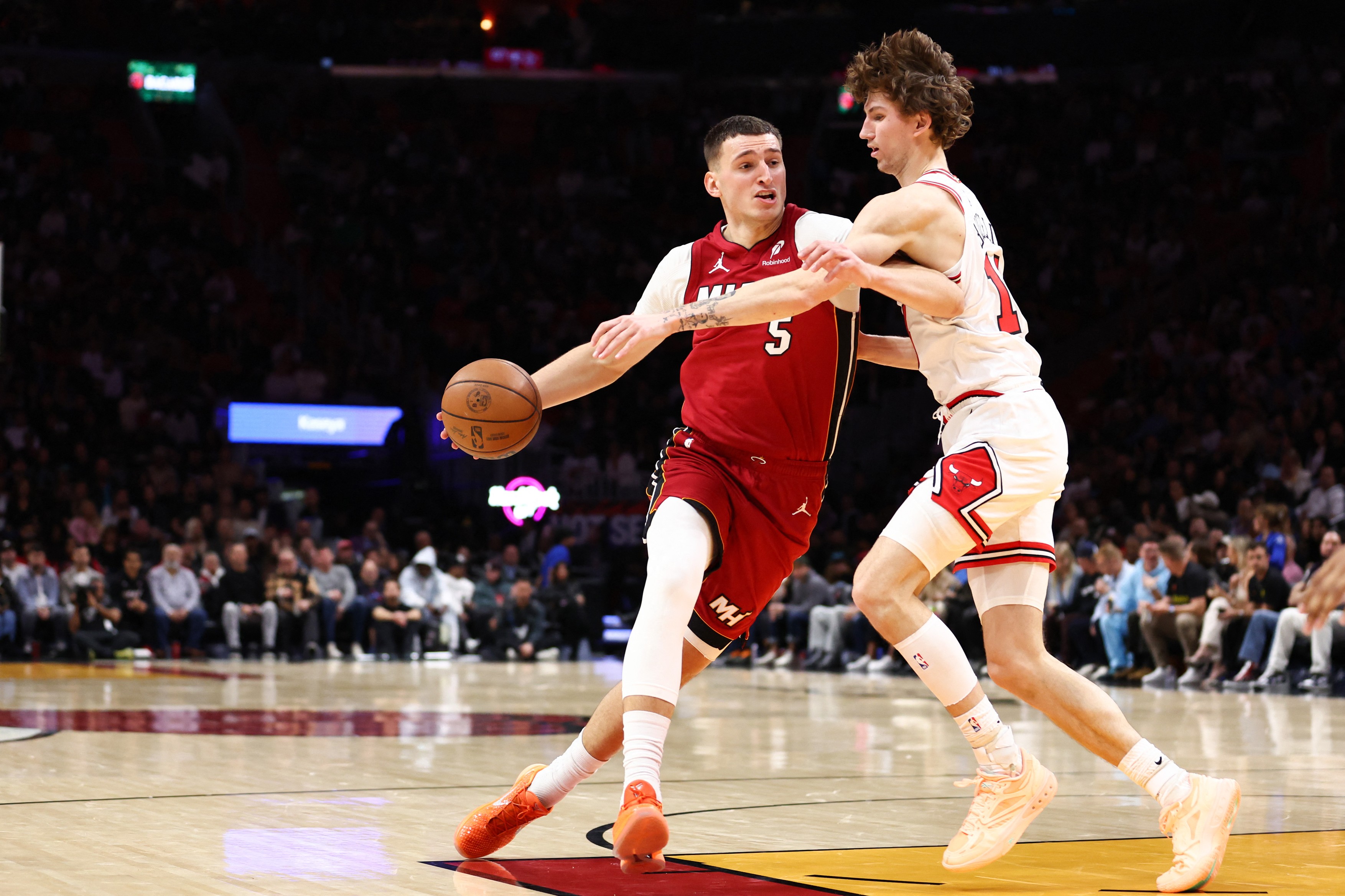 Nikola Jovic #5 of the Miami Heat drives against Matas Buzelis #14 of the Chicago Bulls