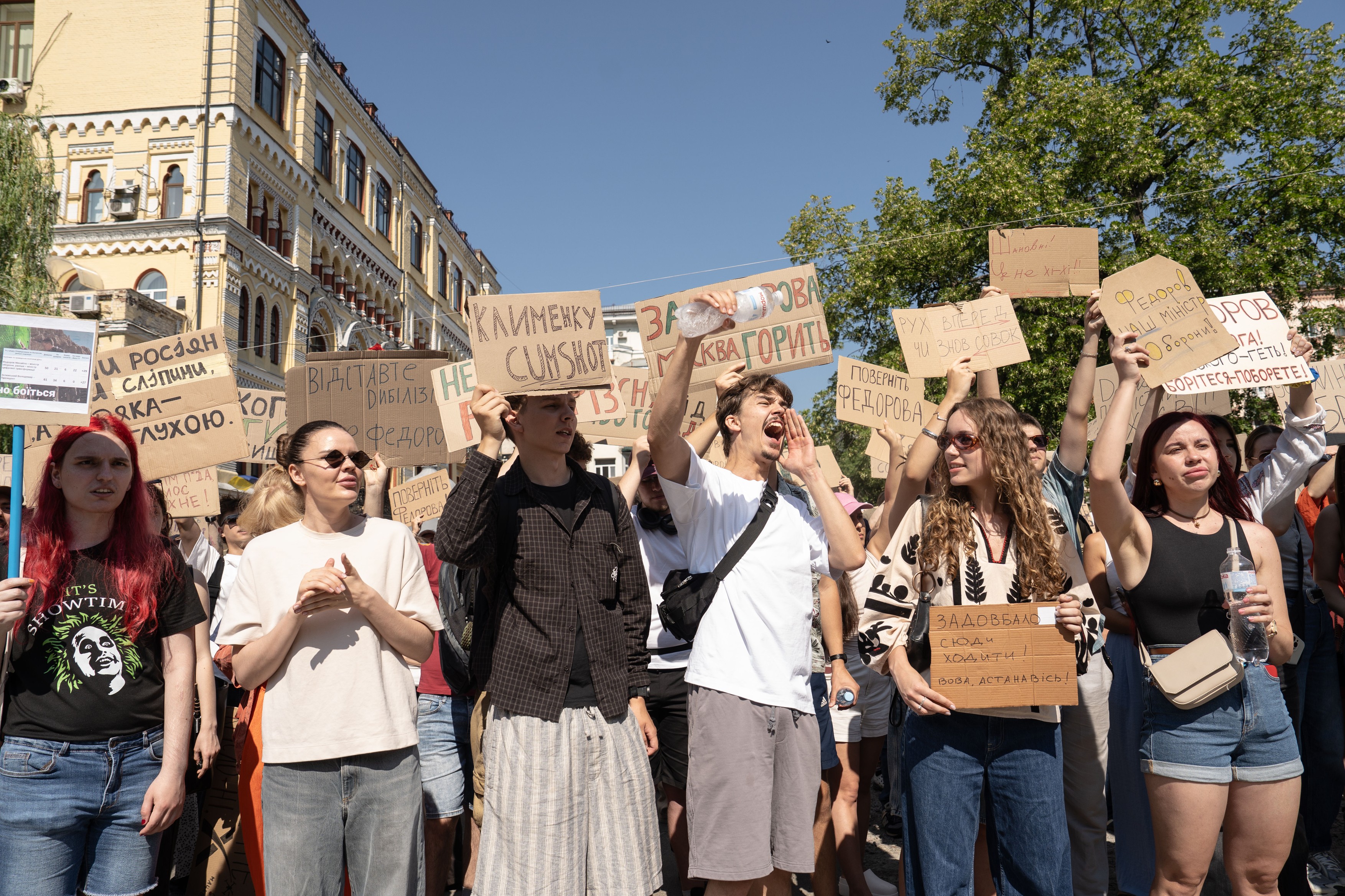 Protesters with placards demonstrate against Ukrainian President Volodymyr Zelenskyy