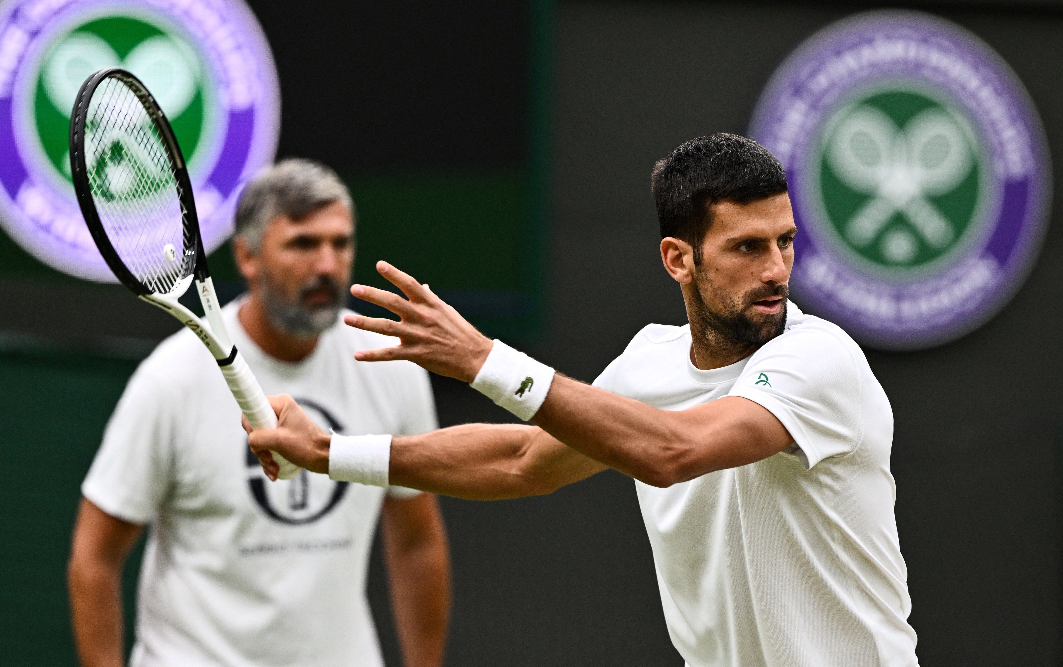Serbia's Novak Djokovic takes part in a practise session with his coach Goran Ivanisevic