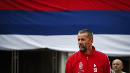 Bogdan Obradović stoji ispred srpske zastave