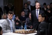 Šahisti Magnus Karlsen i Vesli So poziraju za šahovskom tablom pred početak meča