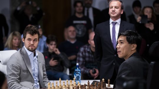 Šahisti Magnus Karlsen i Vesli So poziraju za šahovskom tablom pred početak meča